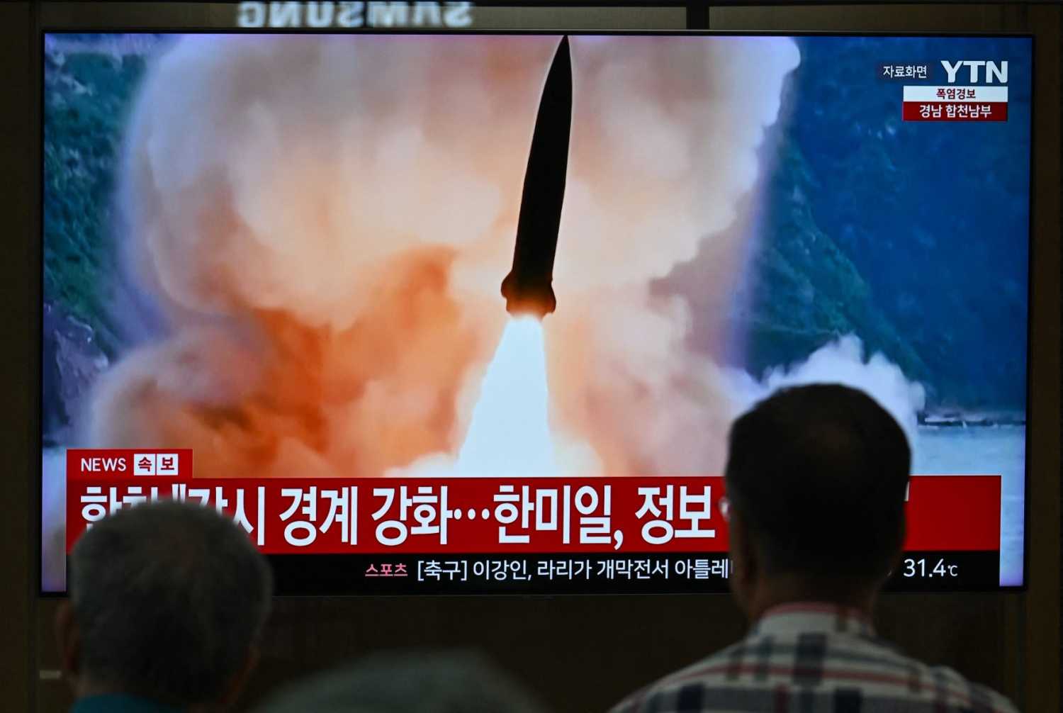 People watch a television screen showing a news broadcast with file footage of a North Korean missile test, at a train station in Seoul on August 20, 2026. North Korea fired around 10 short-range ballistic missiles, South Korea's military said on August 20, hours after US President Donald Trump said he would meet Pyongyang's leader Kim Jong Un later this year.