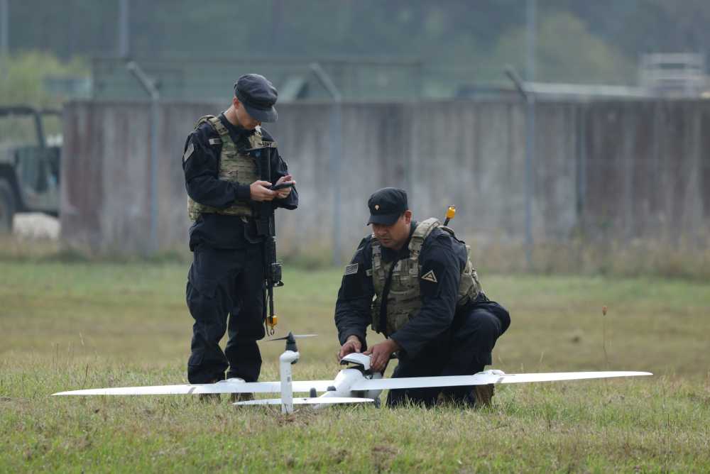 Members of the U.S. Army 7th Army Training Command, clad in black in the role of opposition force, ready a Quantum Systems vector AI eVTOL fixed wing reconnaissance drone during the Saber Junction 26 combined military exercise at the U.S. Army Joint Multinational Readiness Center on August 26, 2026 near Hohenfels, Germany.
