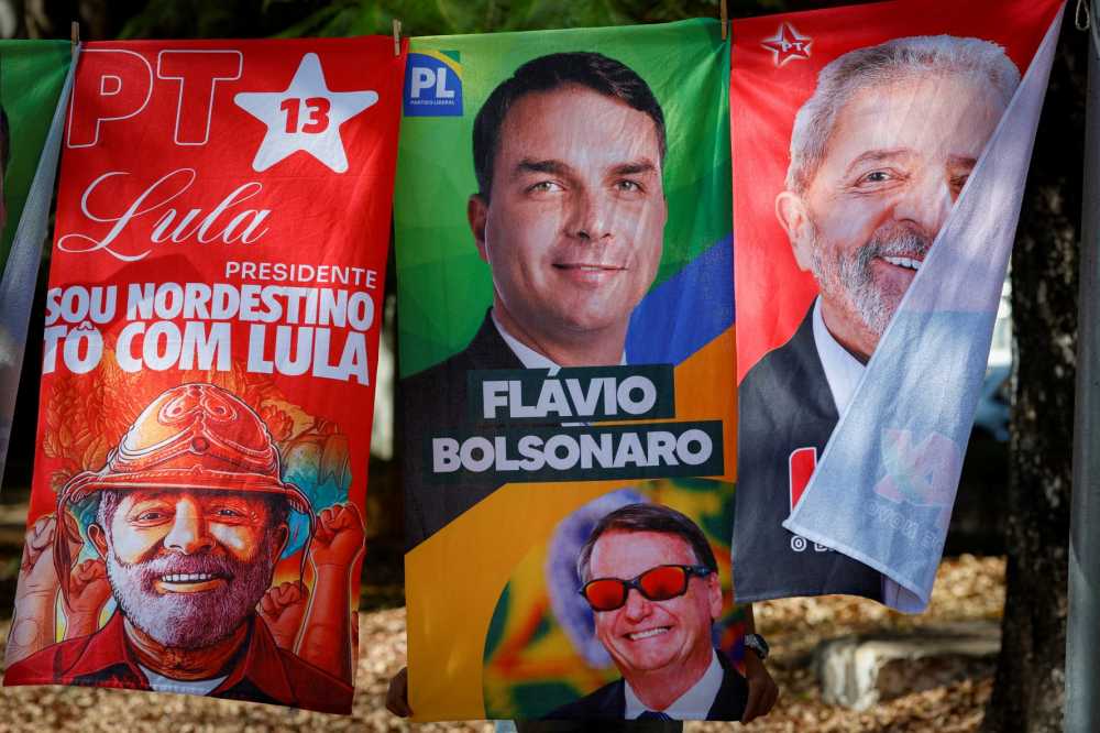 Towels and caps for sale depicting Brazilian presidential candidates Luiz Inacio Lula da Silva and Flavio Bolsonaro are seen in a residential area of Brasília on September 11, 2026. Brazil will hold a presidential elections on October 4, 2026.