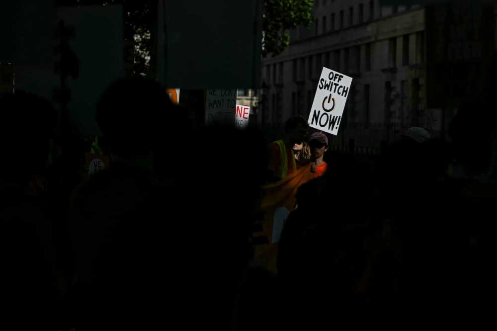 TOPSHOT - A participant holds a placard during a "emergency protest" by civic action group PauseAI UK outside Downing Street in central London on September 16, 2026, after news that AI researcher Jacob Coxon has decided to leave the industry. The world's biggest AI companies are working on creating a standards body, ChatGPT-maker OpenAI said on Sept. 15, as fears rise about the dangers of AI and pressure is on to create a safer version of the technology.