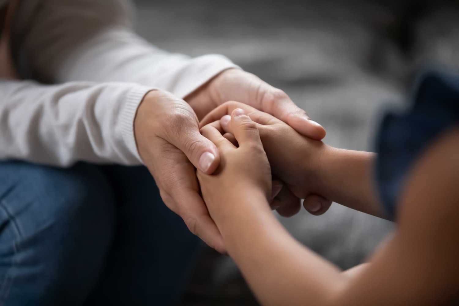 an adult and child holding hands