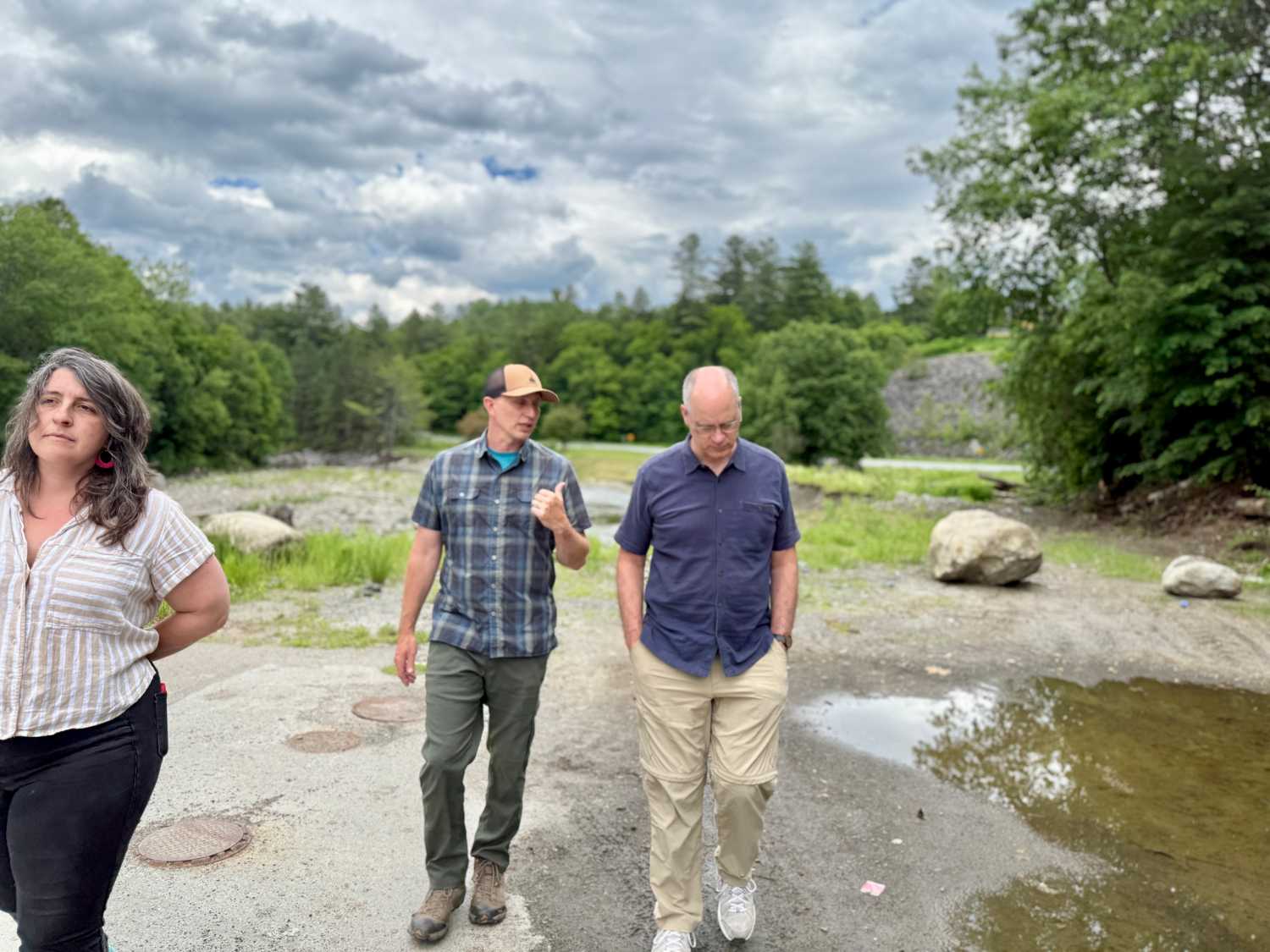 Tony PIpa (r) walks with Opie Upson and Rose Friedman near the Lamoille River, June 2026. (photo by Molly Born)