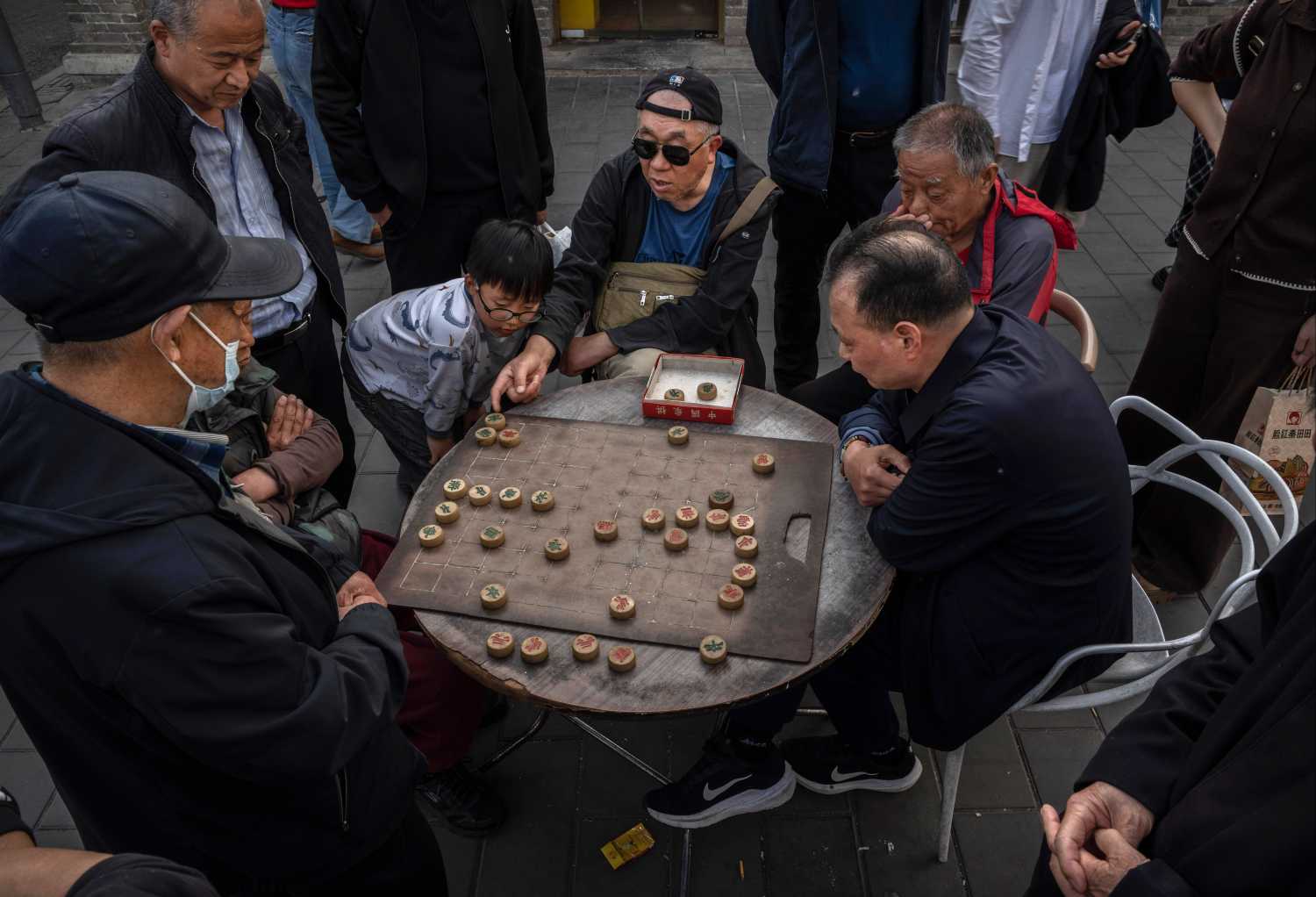 Men play the traditional game Qiangqi, or Chinese chess