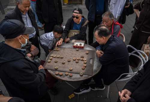 Men play the traditional game Qiangqi, or Chinese chess