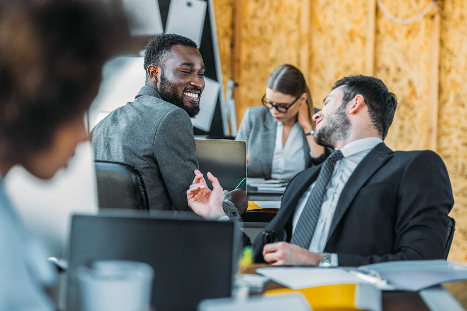 Smiling multicultural businessmen talking in office.