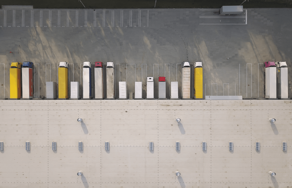 Trucks with shipping containers representing trade and tariffs